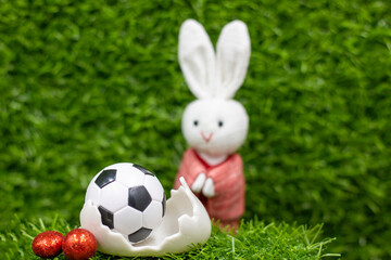 Soccer ball for Easter Holiday with Easter eggs decoration on green grass