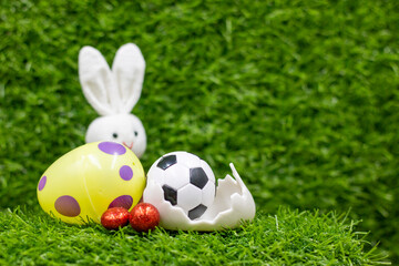Soccer ball for Easter Holiday with Easter eggs decoration on green grass