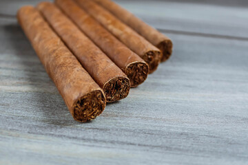 Many cigars on the wooden background. Rolled cigars