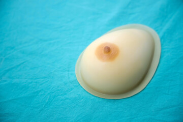 Human female silicone breast simulating model with base for teaching prolactin massage and breastfeeding to lactating woman, student, doctor.