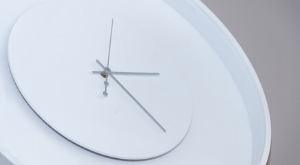 
white wall clock with arrows close up