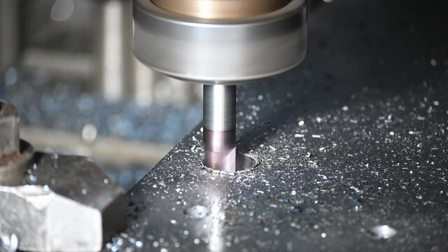 Close-up scene of counterbore cutting process on CNC milling machine with solid end mill tool. The hole processing on machining center.