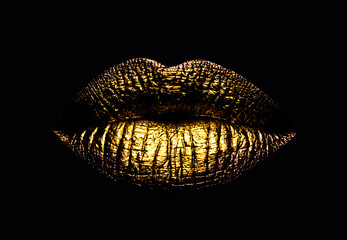 Golden lips closeup. Gold metal lip. Beautiful makeup. Golden lip gloss on beauty female mouth,...