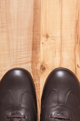 Brown shoes for men on rustic board, male footwear concept, copy space for text