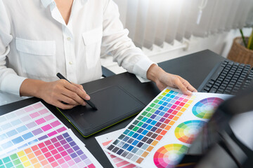 creative graphic designer choosing color scale for editing artwork while working in office.