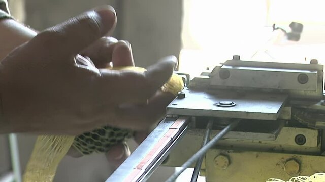 Worker Packing Glass Marbles with a Machine inside a Glass Marble Factory. Close Up.