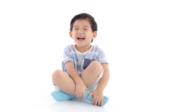 Happy asian boy sitting on white background isolated