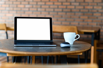 Fototapeta premium Mockup blank screen laptop with coffee on the table,Taken from the front.