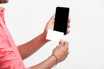 Young indian farmer showing card and smartphone on white background