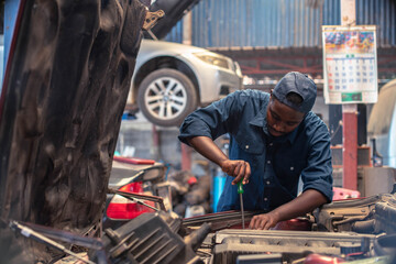 African maintenance male checking tire service via insurance system at garage