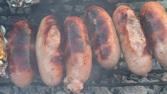 Barbecue braai pork bangers sausages sizzling on hot coals