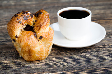 a delicious fresh bun and a cup of black aromatic coffee