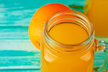 Glass with orange juice on green wooden table