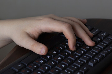 A teenager's hand on the keyboard. Untrimmed nails. Online learning concept, computer games, distance learning, school