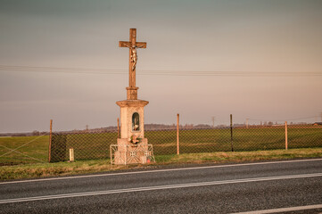 przydrożny murowany krzyż w polu