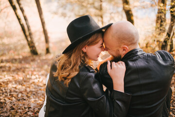 Couple in love wearing fashionable clothes walking in beautiful autumn forest.