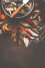 Autumn leaves on dark table with knife and spices. Top view