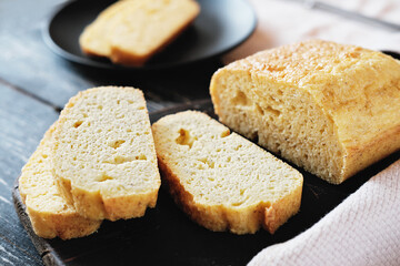 homemade keto bread on grey wooden table. slices of fresh baked low carb bread. LCHF diet concept. flourless baking