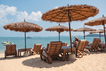 Portrait image of a beautiful young asian woman holding and drinking coconut juice on the beach