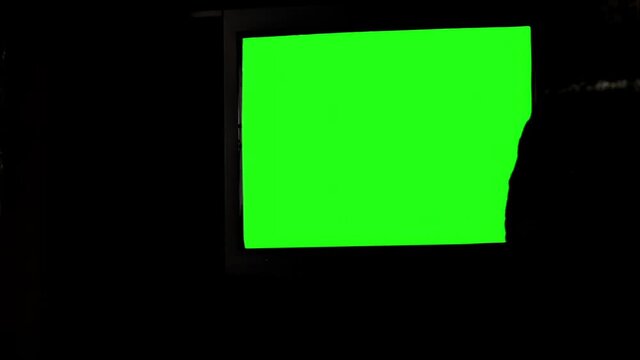 TV Set with Green Screen and the Silhouette of a Man in a Dark Room. You can replace green screen with the footage or picture you want. You can do it with “Keying” effect in After Effects.