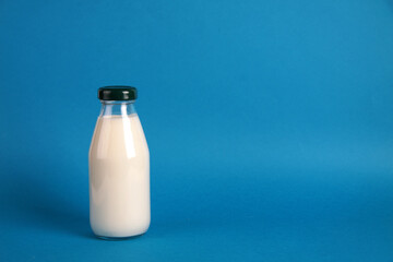 a bottle of kephir isolated on blue background. Fermented food concept