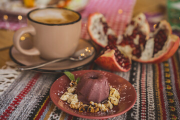 a cup of coffee on a table in a coffe shop in a beige mug . coffee with pomegranat, tea, restaurant, enjoy the taste dessert, cake, pastry, drink coffee, coffee to go,