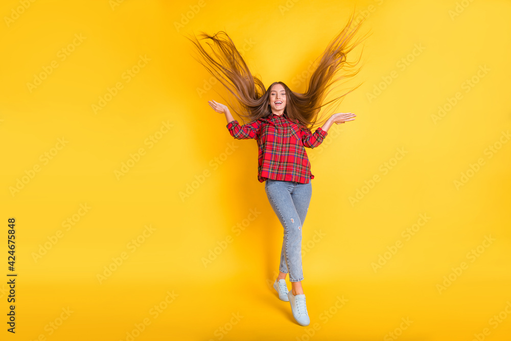 Wall mural full size photo of young happy smiling funky funny girl with long flying hair isolated on yellow col