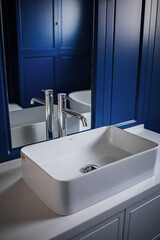 white bathroom sink on blue wall background