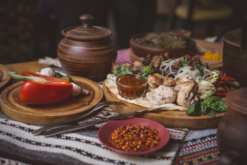 The richly laid table dishes of Georgian cuisine, lots of delicious food,wine,fruits and roasted meat