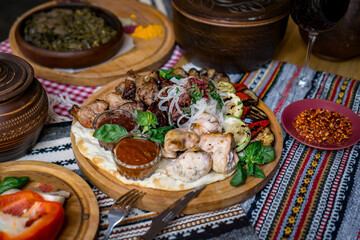 The richly laid table dishes of Georgian cuisine, lots of delicious food,wine,fruits and roasted meat