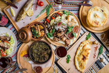A lot of food on the wooden table. Georgian cuisine. Top view. Flat lay . Khinkali and Georgian dishes