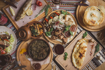 A lot of food on the wooden table. Georgian cuisine. Top view. Flat lay . Khinkali and Georgian dishes