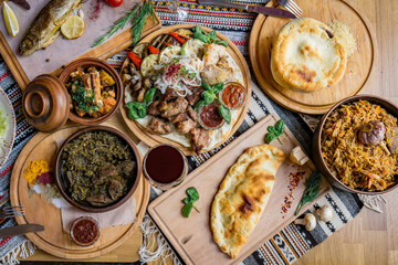A lot of food on the wooden table. Georgian cuisine. Top view. Flat lay . Khinkali and Georgian dishes
