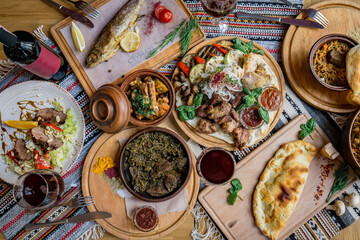 A lot of food on the wooden table. Georgian cuisine. Top view. Flat lay . Khinkali and Georgian dishes
