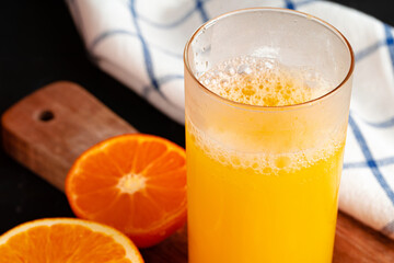 Close up of orange juice glass on wooden table