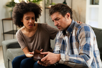 Young man checking empty wallet. Financial troubles in marriage.