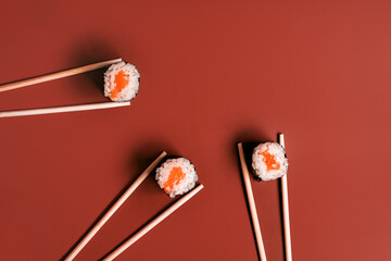 Simple rice and salmon rolls with chopsticks