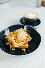 breakfast of Viennese waffles with mousse and cappuccino on the table at the hotel