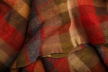 Texture of checkered plaid of warm autumn colors, wrinkled woolen fabric for cozy leisure at home...