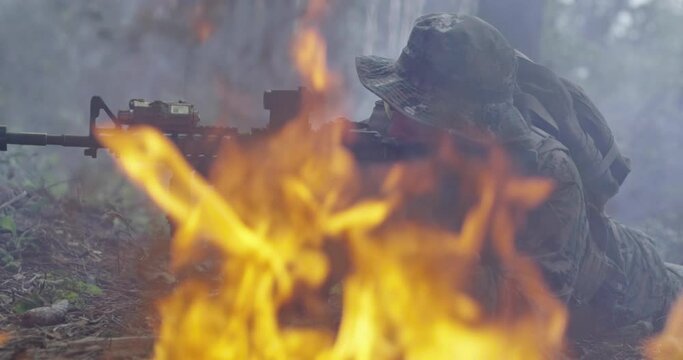 Special Forces soldiers in action. Elite squad moves through fire and smoke in forest