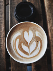 A cup of hot latte, cappuccino or espresso coffee with milk foam on a rustic table, view from top