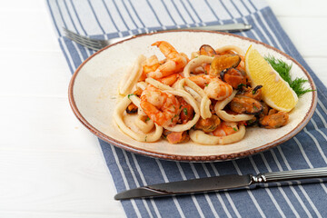 Stir fried seafood with sauce on plate with napkin