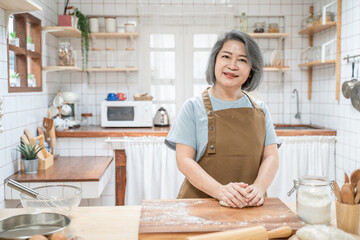 Portrait of Asian senior woman doing homemade bakery in the kitchen.