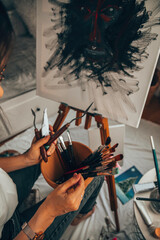 Beautiful talented female artist painting at her home.