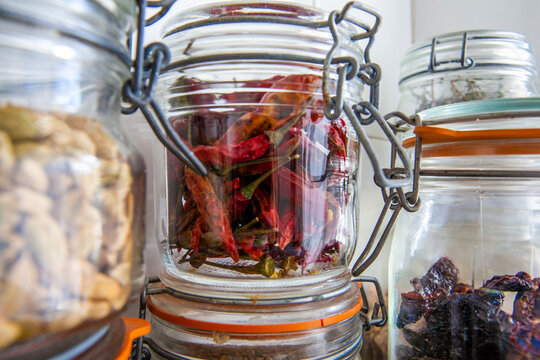 Condimentos en tarro de cristal, ajos, guindilla, pimiento seco. Condiments in glass jar, garlic, chilli pepper, dry pepper.