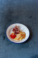Tostada con jamón y tomate  sobre fondo azul. Toast with ham and tomato on a blue background.