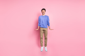 Full size photo of active funky man jump up air travel sale good mood isolated on pastel pink color...