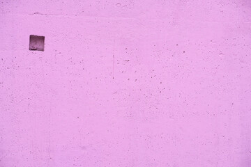 Flat concrete surface with a small niche and many small holes, changed color, bright background
