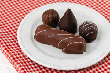 Sweet chocolate candies on white plate close up