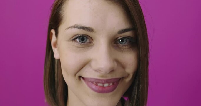 Positive woman smiling over pink backgorund